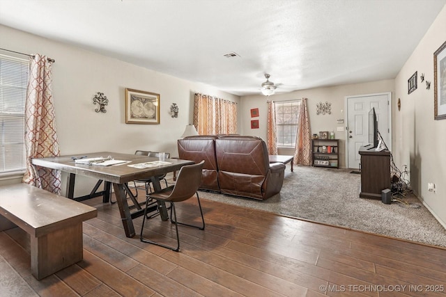 living area with visible vents, wood finished floors, and a ceiling fan