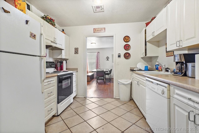 kitchen featuring visible vents, white cabinets, a sink, white appliances, and under cabinet range hood