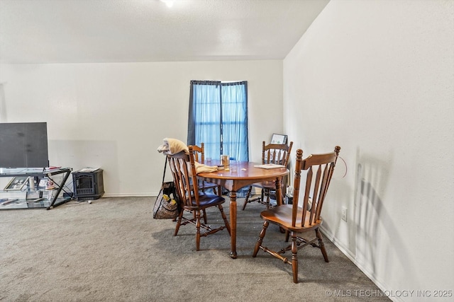 carpeted dining room with baseboards