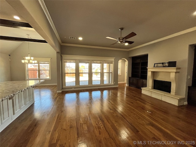 unfurnished living room featuring crown molding, dark wood finished floors, a fireplace with raised hearth, baseboards, and ceiling fan with notable chandelier