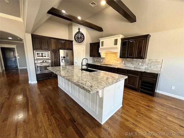 kitchen with tasteful backsplash, visible vents, a spacious island, stainless steel appliances, and a sink