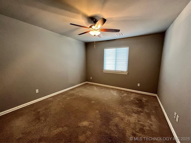 carpeted spare room featuring visible vents, ceiling fan, and baseboards