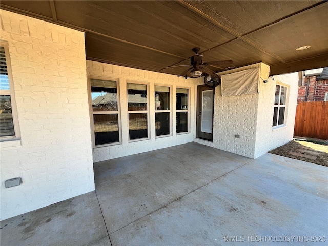 view of patio with ceiling fan and fence