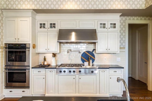 49721 E 95th Rd, Miami, OK 74354 - kitchen with under cabinet range hood, appliances with stainless steel finishes, wallpapered walls, and dark countertops