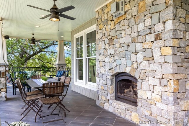 49721 E 95th Rd, Miami, OK 74354 - view of patio with outdoor dining space, a wall mounted AC, an outdoor stone fireplace, and a ceiling fan