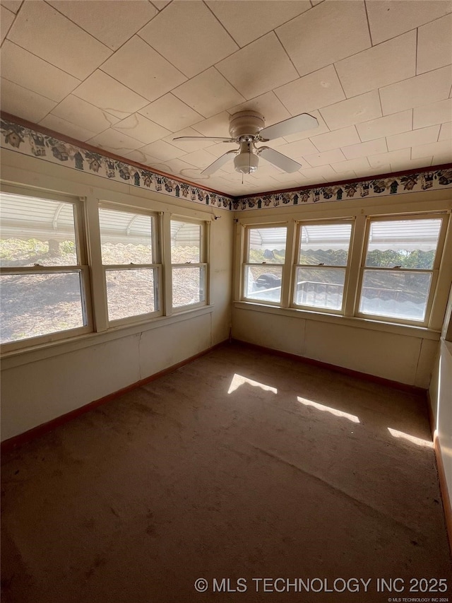 unfurnished sunroom featuring a ceiling fan