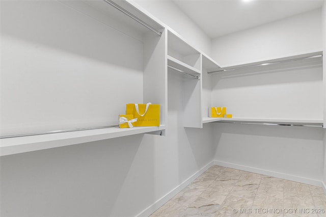 walk in closet with marble finish floor