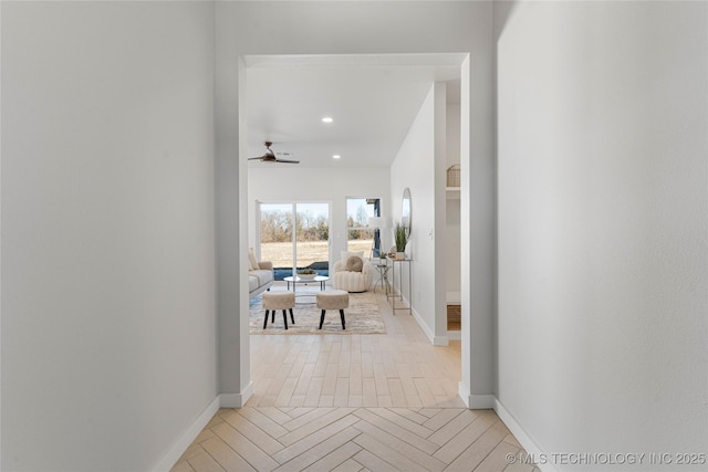 hallway featuring recessed lighting, arched walkways, and baseboards