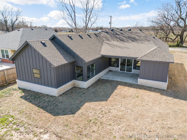 back of property featuring a patio, board and batten siding, fence, and roof with shingles