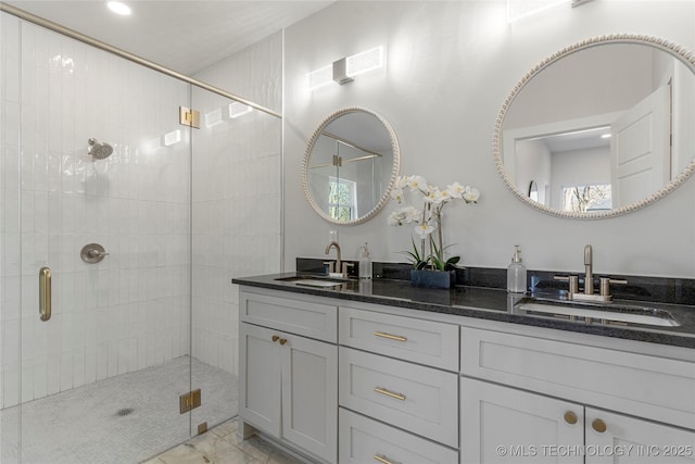 full bath with double vanity, a sink, and a shower stall