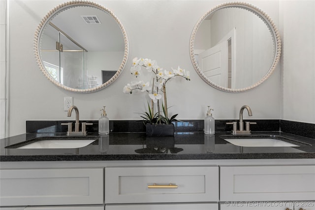 bathroom featuring double vanity, visible vents, and a sink