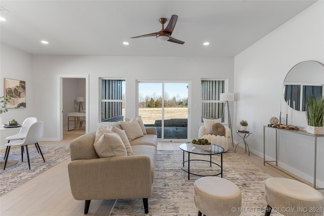 living room featuring light wood-type flooring, a ceiling fan, and recessed lighting