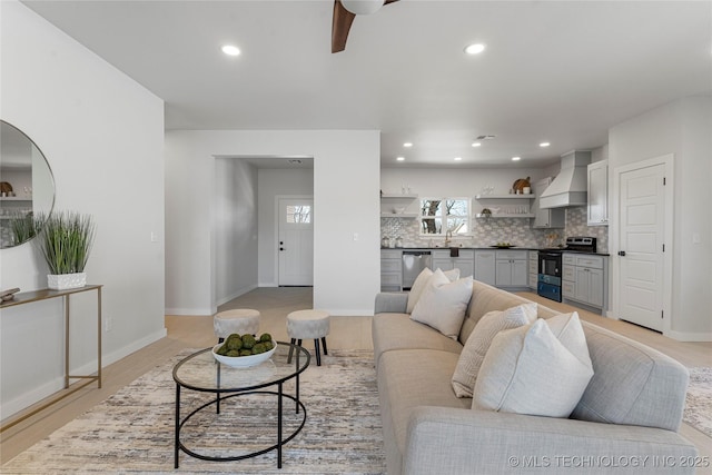 living area featuring light wood-style floors, recessed lighting, ceiling fan, and baseboards