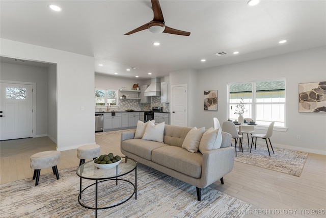 living room with a ceiling fan, recessed lighting, visible vents, and baseboards