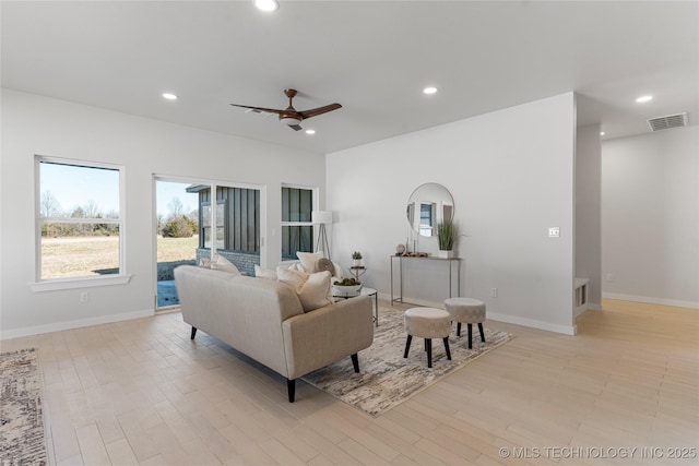 living area with recessed lighting, visible vents, and light wood finished floors