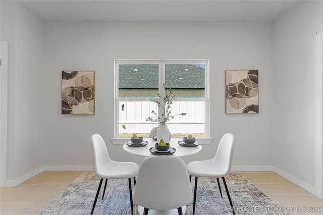 dining area featuring light wood-style floors, baseboards, and a wealth of natural light