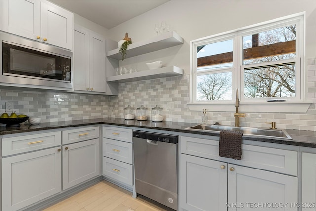 kitchen featuring a sink, appliances with stainless steel finishes, light wood-type flooring, backsplash, and open shelves