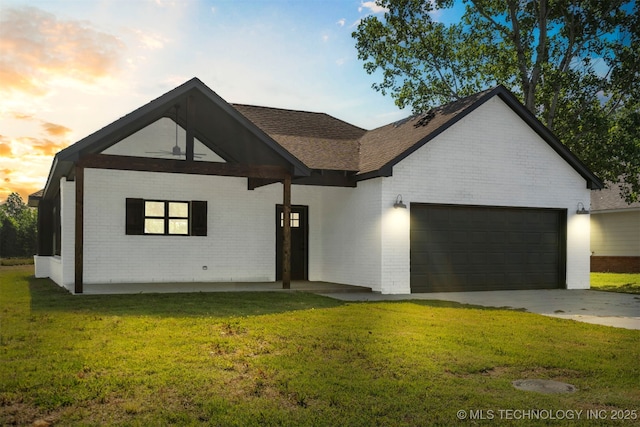 9545 S Cincinnati St, Sperry, OK 74073 - view of front of property with brick siding, an attached garage, a lawn, roof with shingles, and driveway