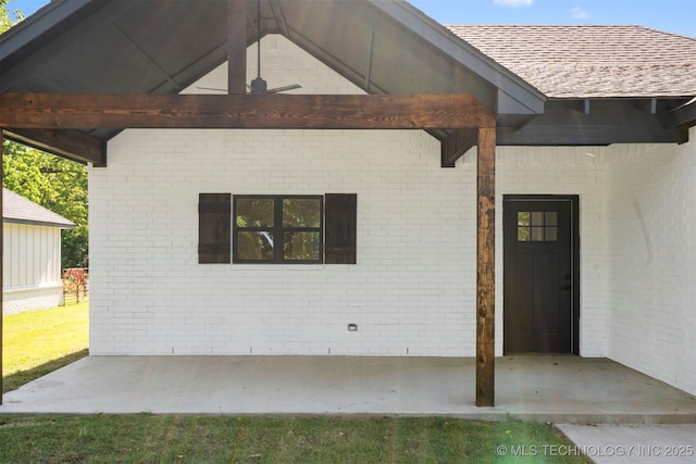 9545 S Cincinnati St, Sperry, OK 74073 - doorway to property with brick siding, a patio area, a ceiling fan, and a shingled roof
