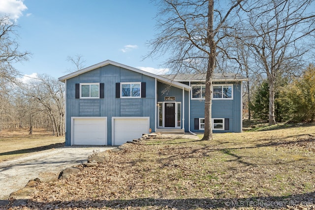 bi-level home with an attached garage and dirt driveway