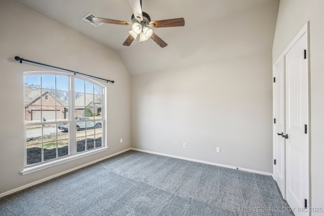 unfurnished bedroom featuring lofted ceiling, a ceiling fan, baseboards, and carpet flooring