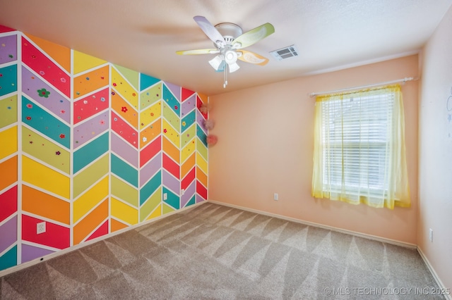 unfurnished room featuring ceiling fan, carpet flooring, visible vents, and baseboards