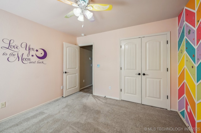 unfurnished bedroom with ceiling fan, a closet, carpet, and baseboards