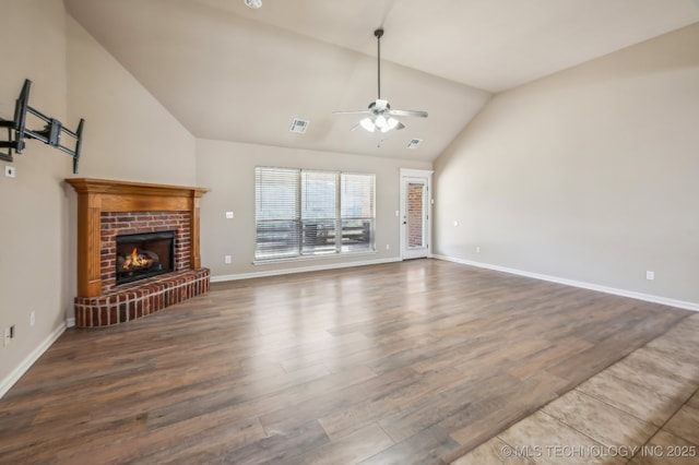 living room featuring a fireplace, visible vents, ceiling fan, wood finished floors, and baseboards