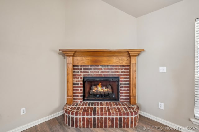 interior details with a brick fireplace, baseboards, and wood finished floors