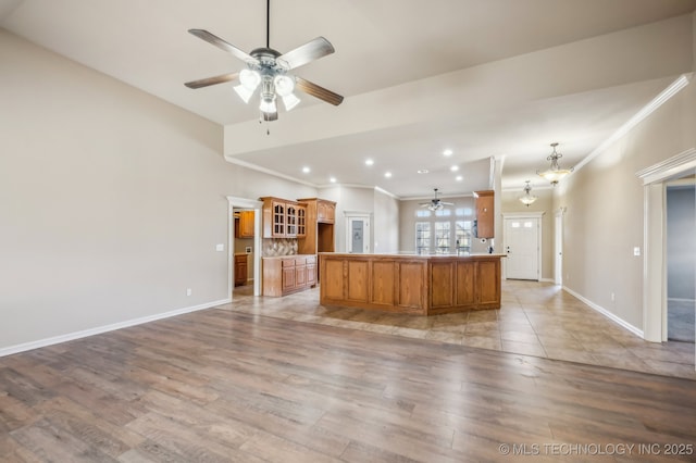 kitchen featuring baseboards, light wood-style flooring, ceiling fan with notable chandelier, crown molding, and recessed lighting