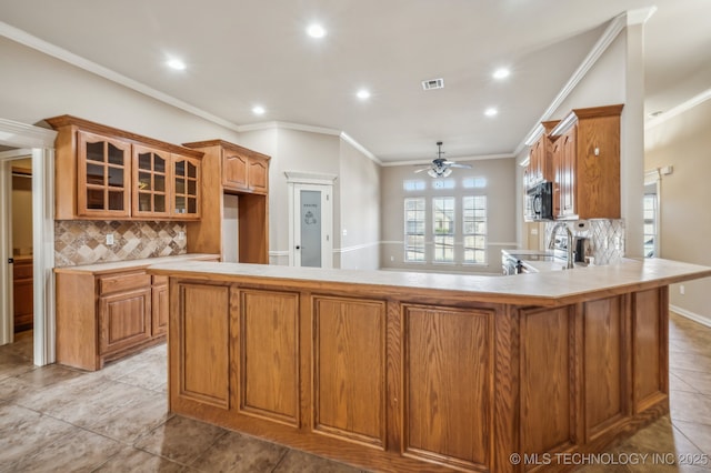 kitchen featuring visible vents, range with electric cooktop, glass insert cabinets, stainless steel microwave, and light countertops