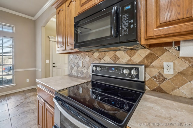 kitchen with light countertops, black microwave, stainless steel range with electric cooktop, and crown molding