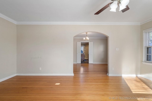 unfurnished room with ceiling fan with notable chandelier, arched walkways, light wood finished floors, and baseboards