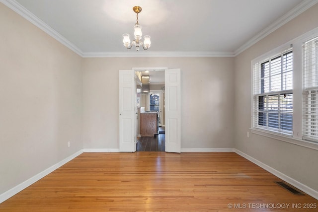 unfurnished room with light wood-type flooring, visible vents, an inviting chandelier, crown molding, and baseboards