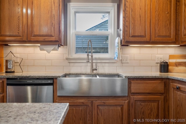 kitchen featuring stainless steel dishwasher, decorative backsplash, brown cabinets, and a sink