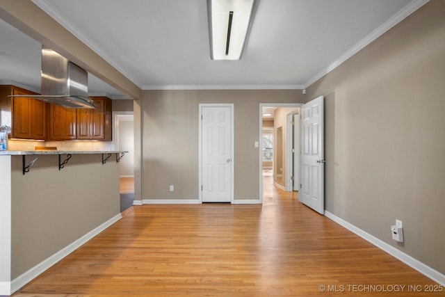 interior space with light wood-style flooring, baseboards, and ornamental molding