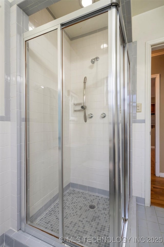 bathroom with tile patterned floors and a shower stall