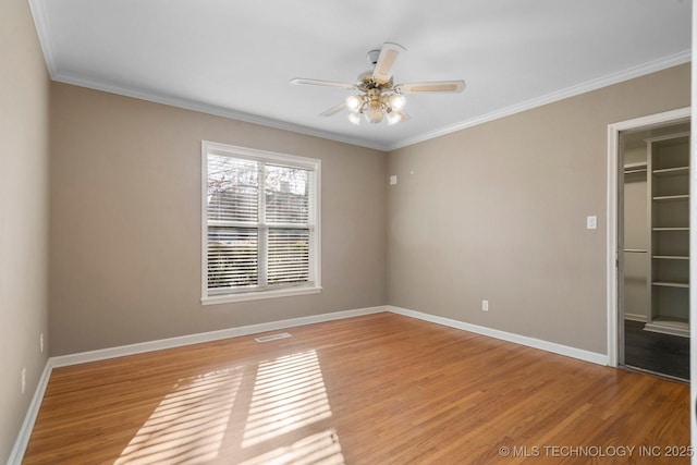 spare room featuring baseboards, a ceiling fan, crown molding, and light wood-style floors