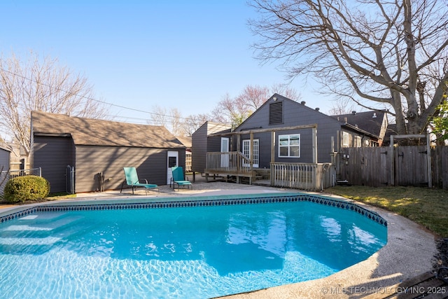 view of pool with a fenced in pool, fence, a wooden deck, a patio area, and a gate