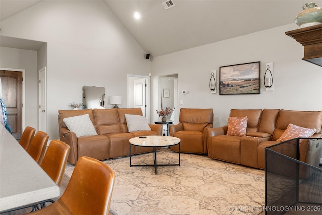 living area featuring visible vents and high vaulted ceiling