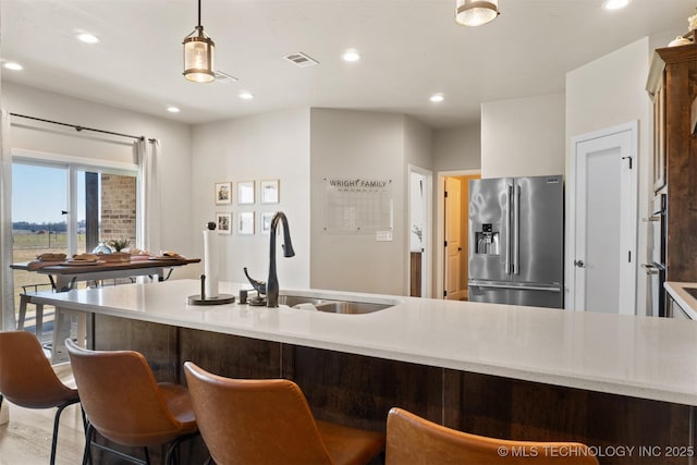 kitchen with recessed lighting, a sink, visible vents, appliances with stainless steel finishes, and decorative light fixtures