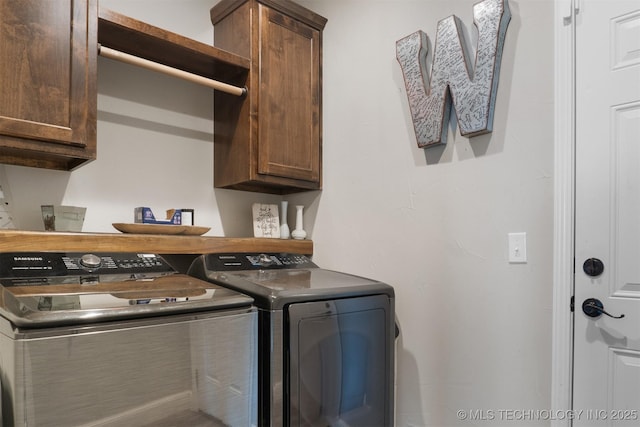 laundry area featuring separate washer and dryer and cabinet space