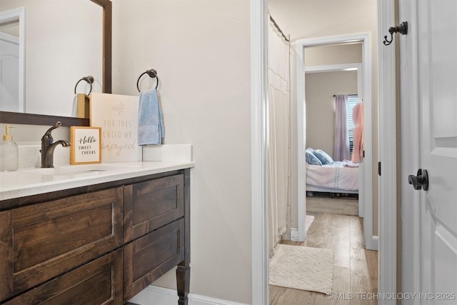 bathroom with ensuite bathroom, wood finished floors, and vanity