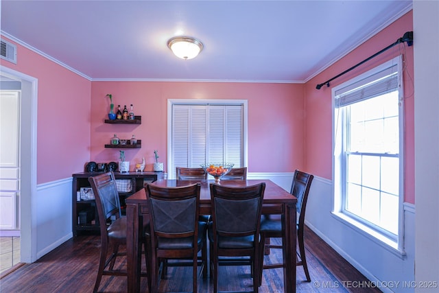 dining room with ornamental molding, dark wood finished floors, and wainscoting