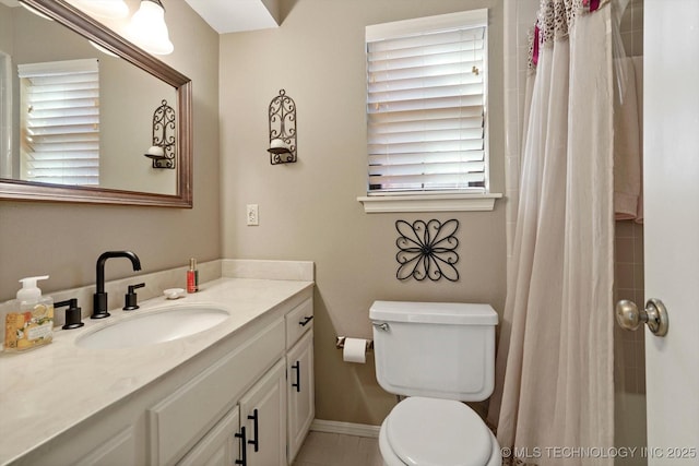 bathroom with curtained shower, vanity, toilet, and baseboards