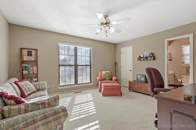 office space with carpet, a textured ceiling, and a ceiling fan