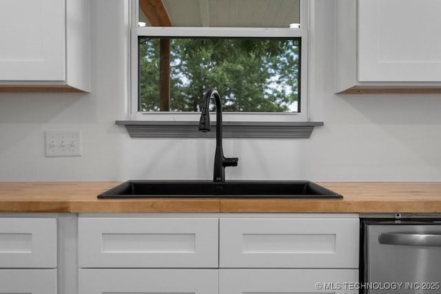 room details with wood counters, white cabinets, and a sink