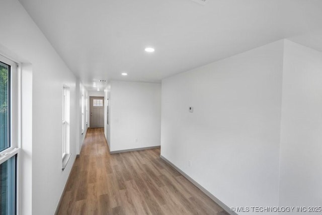 interior space featuring light wood-type flooring, baseboards, and recessed lighting