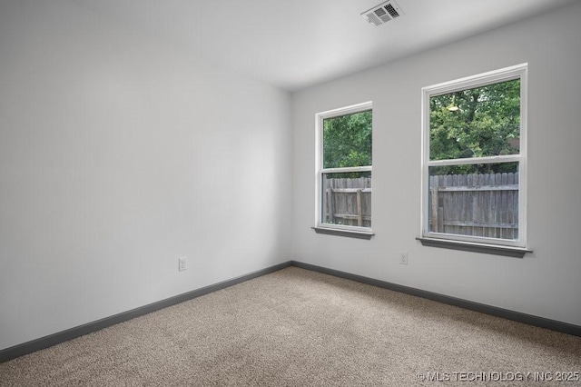 empty room with visible vents, baseboards, and carpet flooring