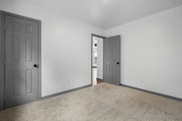 unfurnished bedroom featuring carpet flooring and baseboards